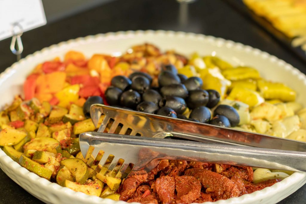 Eine bunte Fruehstuecksplatte mit Oliven, Paprika und weiteren Koestlichkeiten in der Erlebniskueche von Party Buck.